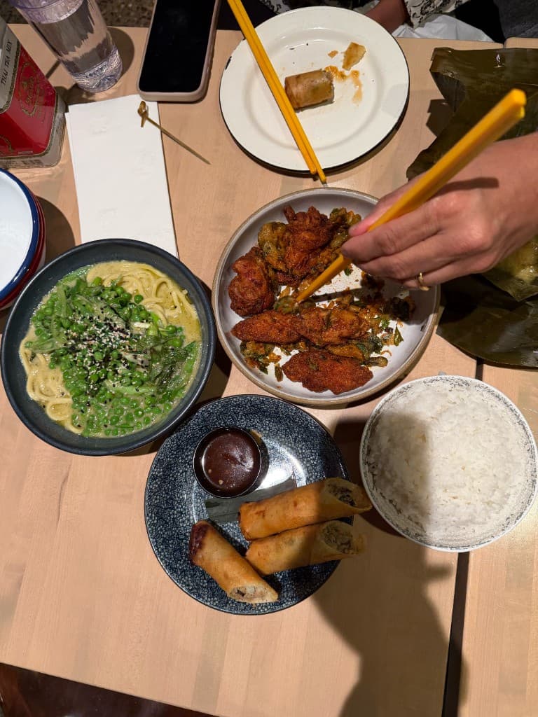 overhead view of fried chicken, spring rolls, noodles, and rice